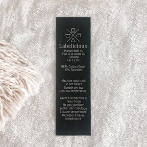 May include: Black and white care label with the text "Labelicious" and instructions for washing and caring for a garment. The label states that the garment is handmade in Canada and is made of 95% cotton and 5% spandex.
