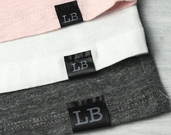 May include: Three fabric swatches with black labels that say "LB" on them. The swatches are pink, white, and grey.