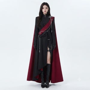 Women's Gothic Cape worn by model, black military-inspired coat with burgundy flowing cape, silver chains and Dark Academia vampire styling