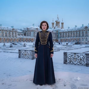 May include: A floor-length dark navy blue coat featuring gold braided military-style detailing across the chest and cuffs. The coat has a high collar, long sleeves, and a structured fit, standing against a backdrop of a large, snow-covered palace.
