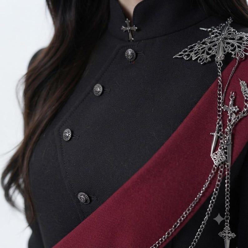 Close-up of women's gothic military coat showing high collar, decorative buttons, silver chains and ornate shoulder embellishment