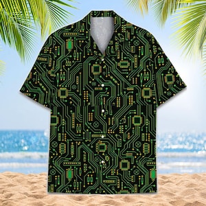 May include: A short-sleeved button-down shirt featuring a black background with a repeating green and yellow circuit board pattern. The design includes various electronic components, microchips, and interconnected lines across the entire fabric.