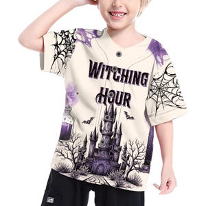 May include: A cream-colored button-down baseball jersey featuring a purple and black graphic print of a gothic castle, spiderwebs, bats, and a potion bottle. The text WITCHING HOUR is printed in a bold, dark font across the center of the chest.