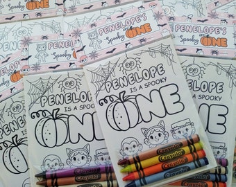 May include: Halloween-themed coloring pages with the text "PENELOPE IS A SPOOKY ONE." Each page features a pumpkin, spiderwebs, and cartoon characters. Packs of Crayola crayons are included.