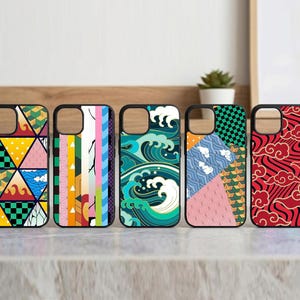 May include: Five black phone cases with colorful geometric and wave patterns. The cases feature designs in red, yellow, blue, green, and pink. The cases are displayed on a light-colored surface.