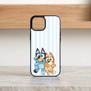 Pu&ograve; includere: Custodia nera per iPhone con un'illustrazione a cartoni animati di due cani. La custodia ha uno sfondo bianco con strisce verticali azzurre. I cani sono blu e arancioni, con contorni neri.