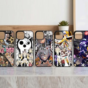 May include: Five black phone cases with colorful anime-style graphics. Each case features a different design, including characters and text from the "Soul Eater" series. The cases are arranged in a row on a light-colored surface.