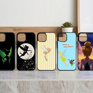 May include: Five phone cases with fairy designs. One case is black with a green fairy silhouette. Another features a fairy silhouette in front of a full moon. Other cases have yellow stripes, a blue background, and a fairy with the text "dream on little dreamer".