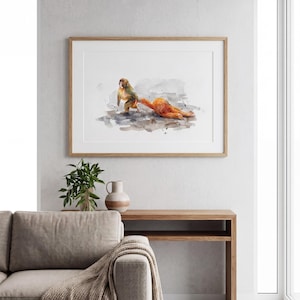 May include: Watercolor print of two monkeys in shades of orange and green, set against a watercolor wash background. The artwork is framed in a light wood frame and hangs on a white wall. The room features a sofa, wooden console table, and decorative vase.