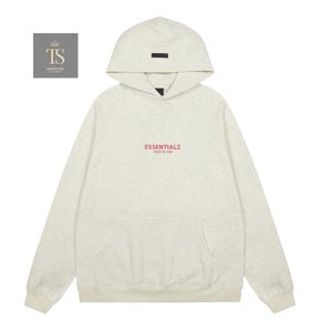 Op de afbeelding: Een lichtgrijs gem&ecirc;leerde hoodie met een capuchon voorzien van een kleine zwarte rechthoekige patch. Op de borst staat de rode tekst ESSENTIALS FEAR OF GOD. Het kledingstuk is voorzien van een kangoeroezak, lange mouwen en boorden.