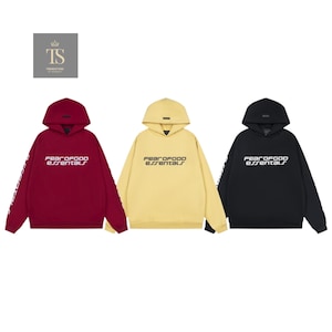 K&ouml;nnte beinhalten: Drei Kapuzenpullover in Burgunderrot, Gelb und Schwarz. Jeder Kapuzenpullover tr&auml;gt den Schriftzug "FEAR OF GOD ESSENTIALS" auf der Brust und am linken &Auml;rmel. Die Sweatshirts haben ein minimalistisches Design mit Kapuze und K&auml;ngurutasche.