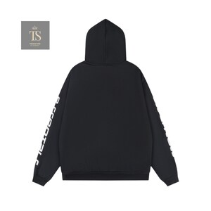 K&ouml;nnte beinhalten: Schwarzer Kapuzenpullover mit wei&szlig;em Text auf den &Auml;rmeln. Der Kapuzenpullover hat eine Kapuze und ein schlichtes Design. Der Text auf den &Auml;rmeln lautet "ESSENTIALS". Der Kapuzenpullover ist aus einem weichen Material gefertigt.