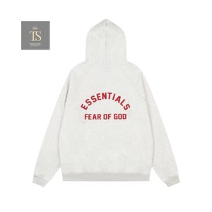 Może przedstawiać: Jasnoszara bluza z kapturem i długimi rękawami. Z tyłu widnieje napis "ESSENTIALS" nad "FEAR OF GOD" w czerwonej, pogrubionej czcionce. Projekt jest minimalistyczny, a bluza ma kaptur.