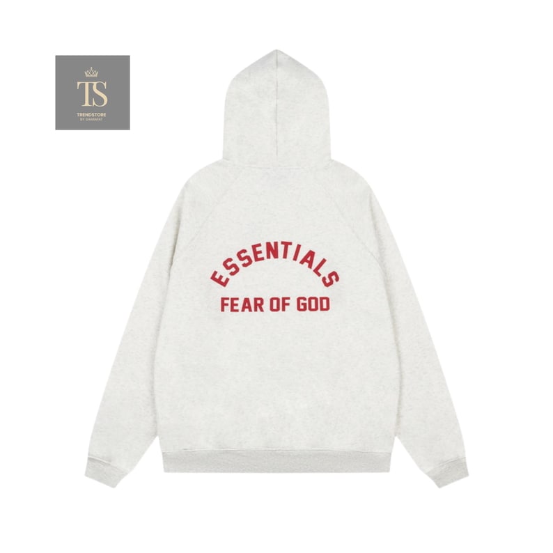 Może przedstawiać: Jasnoszara bluza z kapturem i długimi rękawami. Z tyłu widnieje napis "ESSENTIALS" nad "FEAR OF GOD" w czerwonej, pogrubionej czcionce. Projekt jest minimalistyczny, a bluza ma kaptur.