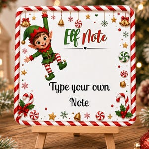 May include: A square sign with a red and white candy cane border featuring a cartoon elf hanging from the top edge. The sign displays the text "Elf Note" and "Type your own Note" in black and green lettering, surrounded by small gold bells, stars, and peppermint candies.