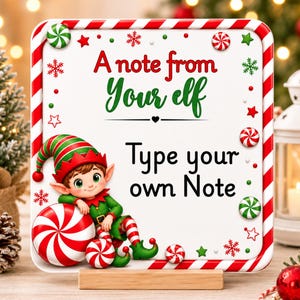 May include: A square white sign with a red and white candy cane border, featuring the text A note from Your elf and Type your own Note. An illustration of an elf in a green and red outfit leans against a large red and white peppermint candy.