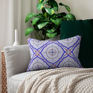 May include: A rectangular throw pillow featuring a light gray background with a repeating pattern of blue curved lines, delicate black vine motifs, and small red and blue floral accents arranged in a symmetrical, tile-like geometric design.
