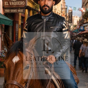 May include: A black leather jacket featuring gold-colored Union Jack flag patterns on the sleeves, a stand-up collar, and a front zipper closure. The jacket is worn with blue denim jeans and a brown cowboy hat, with a logo overlay reading LEATHER LINE.