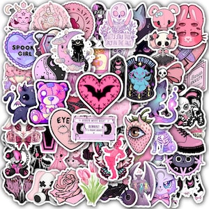 May include: A collection of pink, black, and purple stickers featuring gothic and kawaii themes. Designs include bats, hearts, skulls, cats, and the text "SPOOK GIRL", "HORROR MOVIE NIGHT", and "LET'S STAB THIS DAY IN THE FACE".
