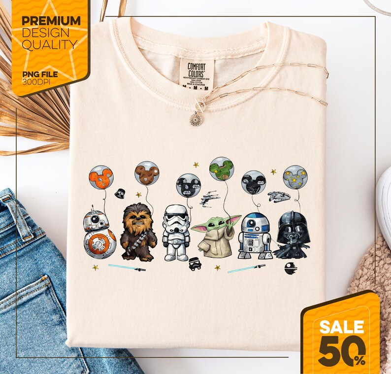 Może przedstawiać: Kremowa koszulka z postaciami z Gwiezdnych Wojen i balonami Myszki Miki. Postacie to BB-8, Chewbacca, Szturmowiec, Grogu, R2-D2 i Darth Vader. Koszulka ma napis "COMFORT COLORS" i "SALE 50%" w prawym dolnym rogu.