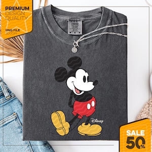 Pu&ograve; includere: T-shirt Comfort Colors grigio scuro con una grafica di Topolino sorridente. Mickey indossa pantaloncini rossi e scarpe gialle. Una collana d'argento con un ciondolo &egrave; sulla maglietta. La maglietta ha il logo Disney e l'etichetta Comfort Colors.