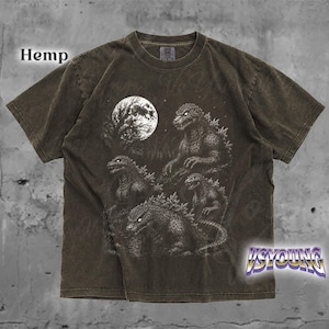 May include: A dark brown short-sleeve t-shirt featuring a graphic print of four Godzilla-like creatures under a large full moon and starry night sky. The word Hemp is printed in the upper left corner and the text VSYOUNG is in the bottom right.