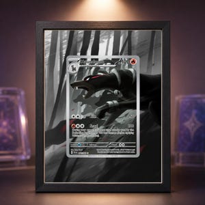 Könnte beinhalten: Eine gerahmte Houndoom Pokémon-Sammelkarte. Die Karte zeigt eine Schwarz-Weiß-Illustration des Pokémon. Die Karte befindet sich in einem schwarzen Rahmen vor einem graustufigen Hintergrund.