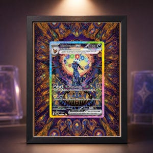 May include: Framed Umbreon EX Pokemon card. The card features a black and blue Umbreon illustration with the text "Moon Mirage" and "Onyx". The frame is black, and the background is a colorful, patterned design with purple, gold, and blue hues.