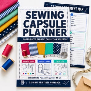 May include: A Sewing Capsule Planner workbook with a white cover featuring dark blue text, fabric swatches, and illustrations of garment roles, patterns, and wear tests. Includes a measuring tape, spools of thread, and a Capsule Garment Map page.