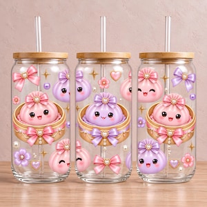 May include: Three clear glass tumblers with bamboo lids and glass straws, decorated with a pattern of smiling pink and purple dumplings in bamboo steamers, accented by pink and purple bows, small flowers, hearts, pearls, and gold star sparkles.