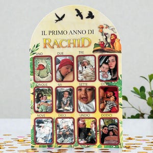 Könnte beinhalten: Ein dekoratives Foto-Display mit zwölf kleinen Fotorahmen, die jeweils einen Monat darstellen. Das Display ist oben gewölbt und trägt den Text "IL PRIMO ANNO DI RACHID" sowie Illustrationen von Vögeln und Figuren. Die Rahmen sind in drei Reihen angeordnet.