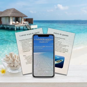 Peut inclure: Un smartphone affiche le texte "30 hôtels de rêve aux Maldives" avec une scène de plage. Deux feuilles imprimées avec du texte en français sont derrière le téléphone. Un petit bol en verre avec du corail et une fleur blanche sont au premier plan.