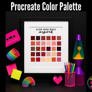 May include: A framed print with a color palette titled "Procreate Color Palette" and the text "Blood Moon Magic Inspired." The palette features a grid of various shades of red, pink, and brown. Surrounding the frame are a pink cassette tape, a rainbow slinky, and a purple lava lamp.