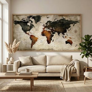 May include: A large framed world map with a vintage aesthetic. The map features a detailed depiction of continents in shades of brown, black, and beige. The map is mounted on a light-colored wall above a beige sofa, creating a warm and inviting atmosphere.