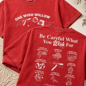 May include: Two red t-shirts with white graphic text and illustrations. The front shirt reads "ONE WISH WILLOW" with illustrations. The back shirt says "Be Careful What You Wish For" with wish-related drawings.