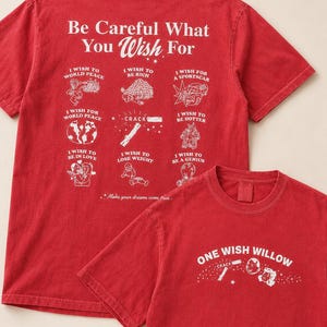 May include: Two red t-shirts with white text and illustrations. The larger shirt says "Be Careful What You Wish For" with various wish-related graphics. The smaller shirt says "ONE WISH WILLOW" with a graphic. Both shirts are short-sleeved.