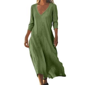 May include: A green, V-neck dress with three-quarter sleeves. The dress has a loose, flowing design and falls to mid-calf length. The fabric appears to be a lightweight linen or cotton blend, suitable for warm weather.