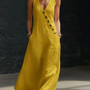 May include: A sleeveless, mustard yellow dress with a V-neckline and a row of black buttons down the side. The dress has two front pockets and a flowing, relaxed fit, suitable for warm weather.