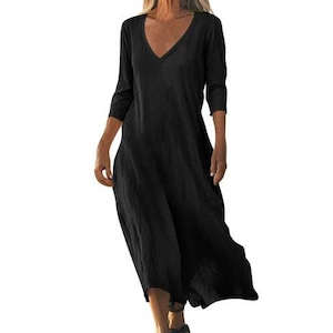 May include: A black, long-sleeve dress with a V-neck. The dress has a loose, flowing design and falls to mid-calf. The fabric appears to be a lightweight material, suitable for warmer weather. The dress is a solid black color.