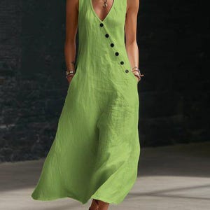 May include: A sleeveless, lime green jumpsuit with a V-neckline and a row of black buttons down the front. The jumpsuit has pockets and a flowing, wide-leg design, made of a lightweight fabric.