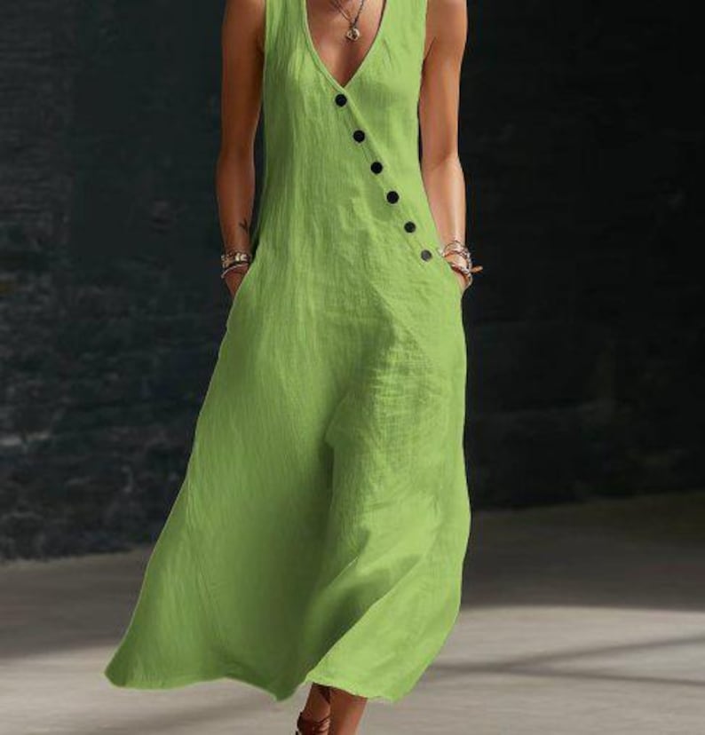 May include: A sleeveless, lime green jumpsuit with a V-neckline and a row of black buttons down the front. The jumpsuit has pockets and a flowing, wide-leg design, made of a lightweight fabric.