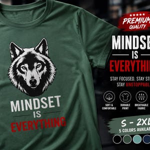 May include: A dark green t-shirt featuring a black and white wolf head graphic above the white and red text "MINDSET IS EVERYTHING". The image includes additional text: "PREMIUM QUALITY", "STAY FOCUSED. STAY STRONG. STAY UNSTOPPABLE.", and size options S-2XL.