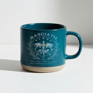 May include: Teal ceramic mug with a beige base. The mug features the text "BASGIATH WAR COLLEGE" in white, along with a graphic of a sword and wings. The bottom of the mug has the quote, "There's nowhere in existence you could go that I wouldn't find you, Violence."