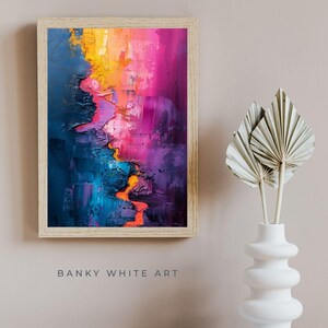 Op de afbeelding: Abstracte kunstafdruk in een licht houten frame. Het kunstwerk heeft een levendig kleurenpalet, waaronder blauw, oranje, roze en paars. De tekst "BANKY WHITE ART" staat onderaan het frame.