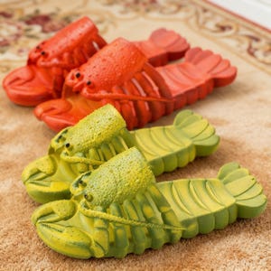 Puede incluir: Sandalias con forma de langosta en rojo y verde lima. Las sandalias están diseñadas para parecerse a langostas, con garras, ojos y cuerpos segmentados detallados. Zapatos divertidos para la playa o el uso diario.