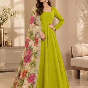 Può includere: Un abito lungo color verde lime a maniche lunghe con scollo quadrato e pantaloni a gamba larga abbinati. L'outfit include un dupatta color crema caratterizzato da una vivace stampa floreale nei toni del rosa, rosso e verde con bordo in pizzo.