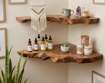 May include: Two natural edge wooden corner shelves mounted on a wall. The top shelf holds a macrame wall hanging, a ceramic mug, and two crystals. The bottom shelf displays five amber glass dropper bottles, a small succulent, and three candles.