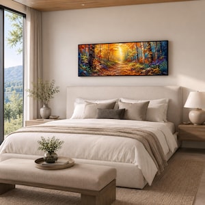 May include: A panoramic rectangular wall art print featuring a vibrant autumn forest scene with golden sunlight filtering through trees, displayed in a black frame above a neutral-toned upholstered bed in a bedroom setting.