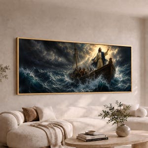 May include: A rectangular wall art print in a thin gold frame depicting a wooden boat on turbulent, dark blue ocean waves during a storm. A figure in a white robe and blue cloak stands at the bow with one arm raised toward a bright light.