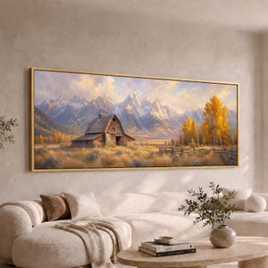 May include: A panoramic landscape painting in a gold frame depicting a weathered wooden barn in a golden field. In the background, snow-capped mountain peaks rise under a soft, light-filled sky. Vibrant yellow autumn trees stand to the right.